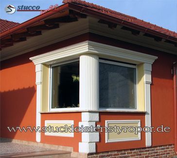 Fensterverzierung mit kannelierter Säule und verschiedenen Fassadenprofilen