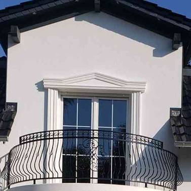 beschichteter Fassadenstuck Bogengiebel über der Balkontür