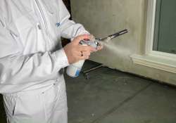 Austrittsöffnung der Schaumpistole zum Reinigen besprühen